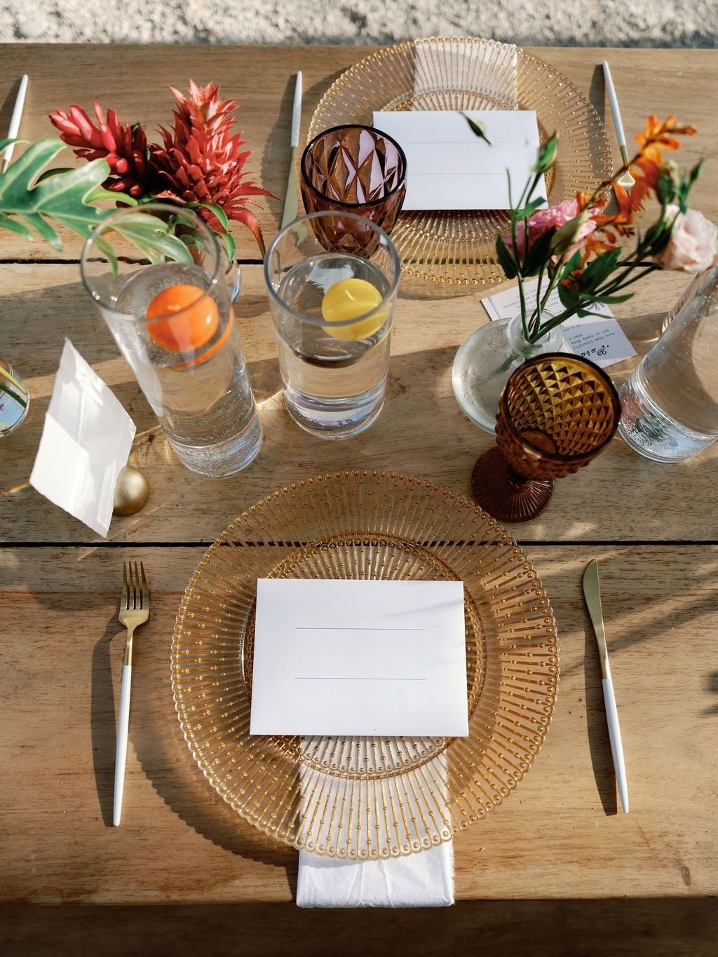 Place setting from above: gold relief charger, gold-and-white cutlery, amber and purple glassware