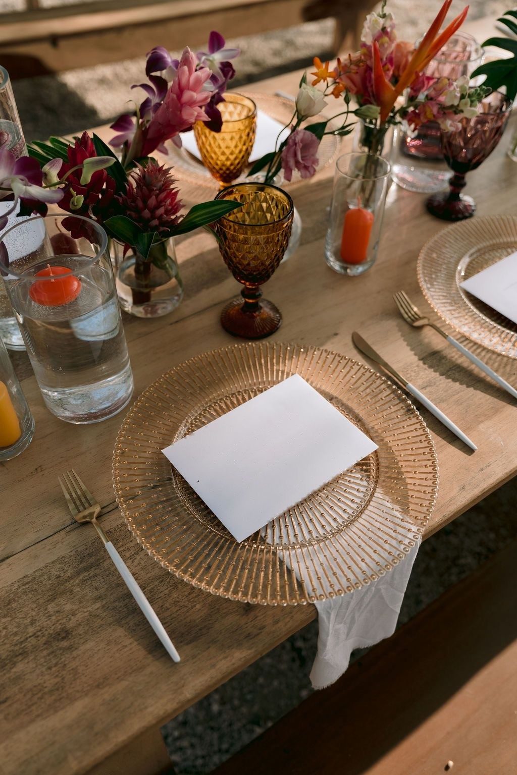 Gold relief charger with gold-and-white cutlery and amber goblets