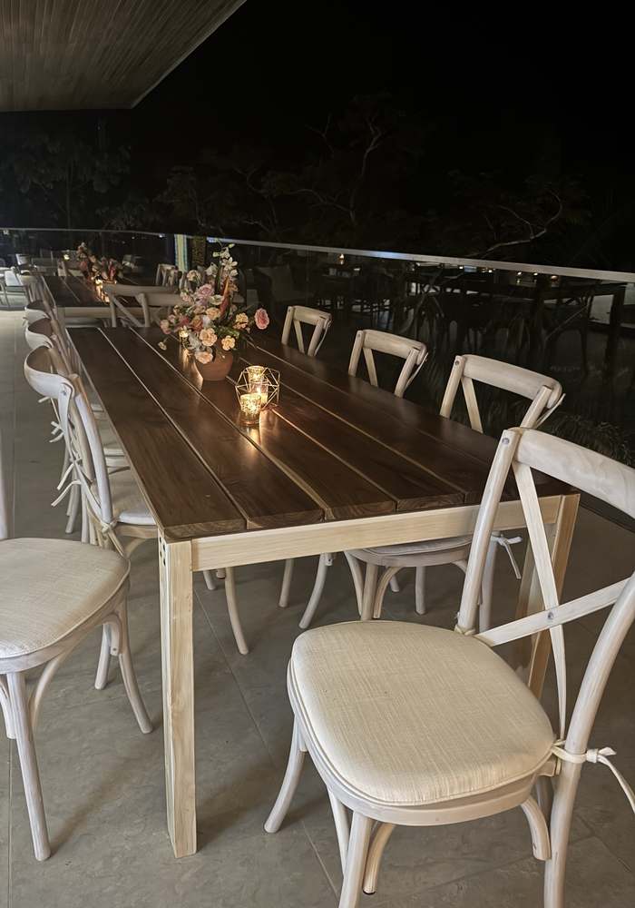 Teak table: Set for an evening wedding dinner with white crossback chairs