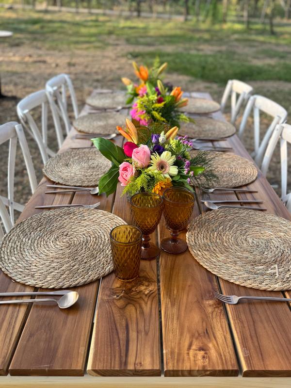 Wicker charger: Set on a teak table with amber glassware